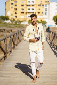 Full length of young man walking on footpath