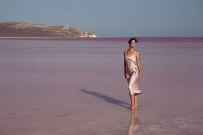 Woman on a dried up salt lake in a pink dress in the crimea