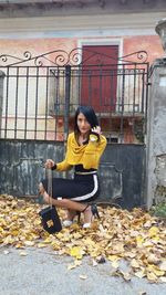 Woman sitting in park during autumn