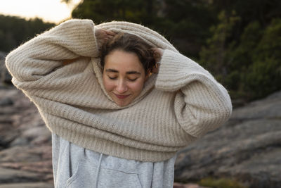 Woman putting jumper on