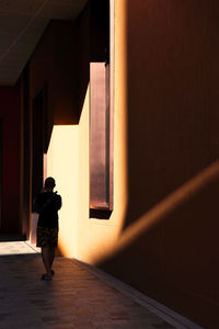 Rear view of woman walking on footpath