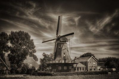 Traditional windmill on field against sky