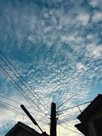 Low angle view of electricity pylon against sky