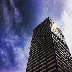 Low angle view of modern building against cloudy sky