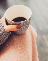 Close-up of hand holding coffee cup