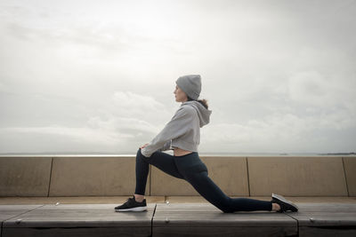 Sporty woman doing leg stretching exercises, outside. outdoor workout.