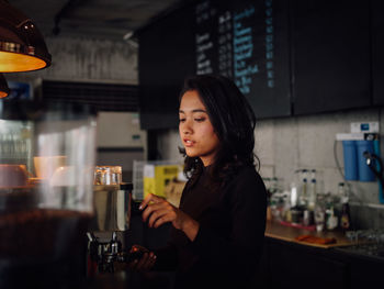 Young woman looking at camera at restaurant