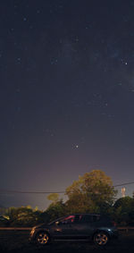 Cars on road against sky at night