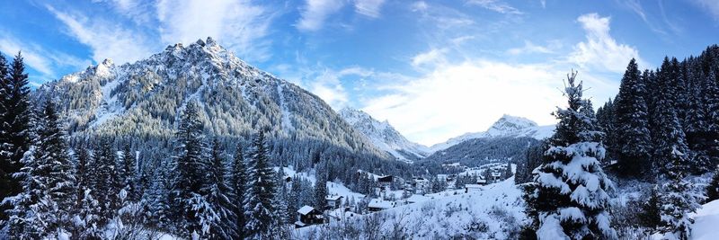 Scenic view of snow covered mountains against blue sky