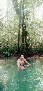 Young man in water at forest