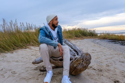 Young man sitting on rock