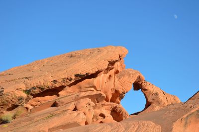 Low angle view of rock formations against blue sky