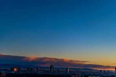 Scenic view of city against clear sky at sunset