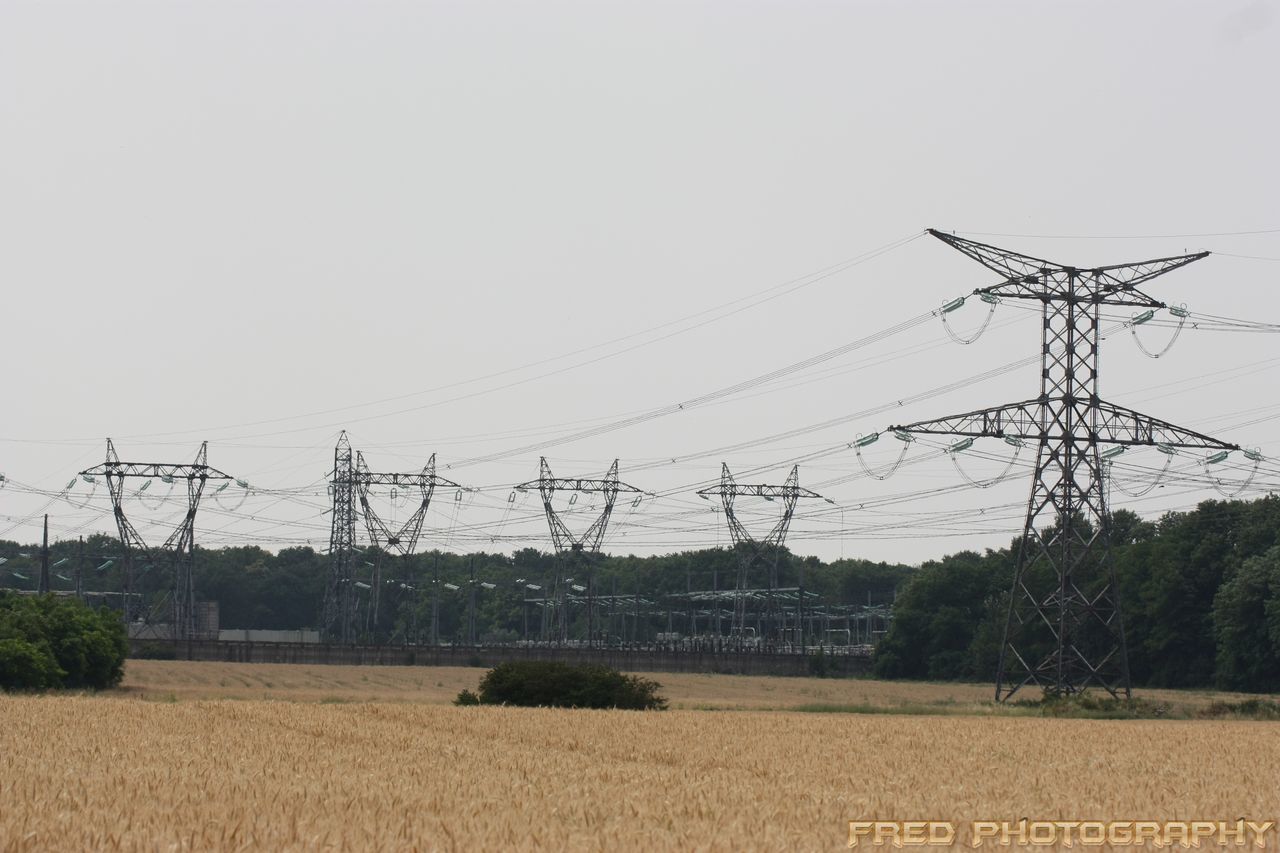building exterior, clear sky, field, built structure, rural scene, fuel and power generation, architecture, agriculture, landscape, electricity pylon, power line, farm, copy space, tree, house, sky, technology, electricity, nature, outdoors