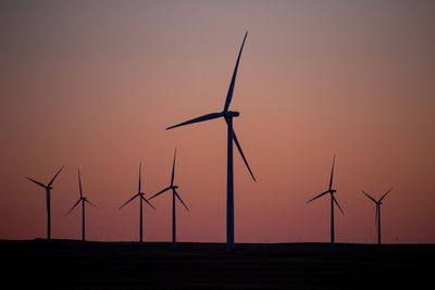 Low angle view of windmills against clear sky