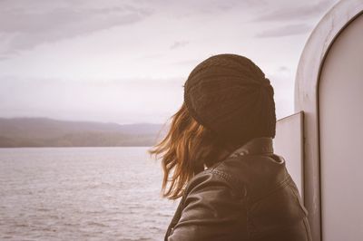 Rear view of woman looking at sea against sky