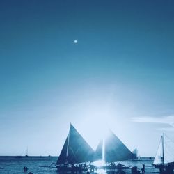 Sailboats in sea against clear sky at night