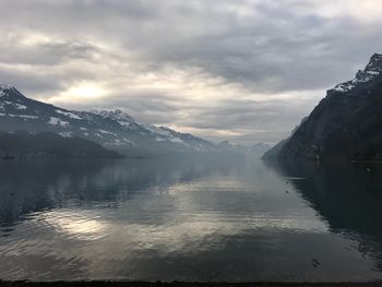 Scenic view of lake and snowcapped mountains against sky