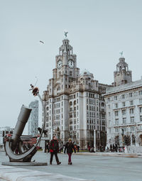 People on street with buildings in city