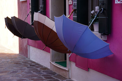 Close-up of umbrella on footpath against wall