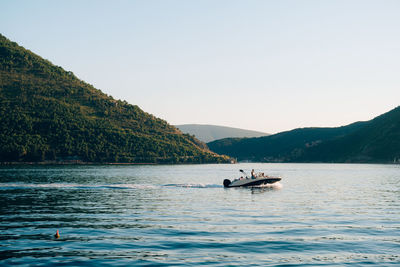 Boat sailing on sea against clear sky