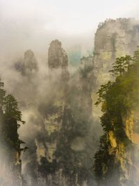 Scenic view of mountains against sky during foggy weather