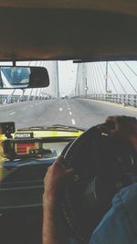 Close-up of man driving car on road