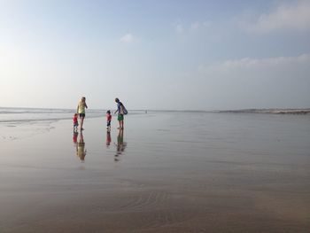 Family at beach against sky