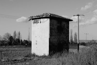 Abandoned house on field against sky