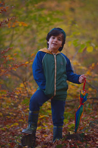 Portrait of boy standing in forest