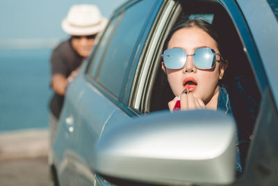 Portrait of woman wearing sunglasses in car