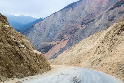 Scenic view of road amidst mountains against sky