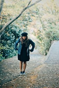 Full length of woman standing on footpath