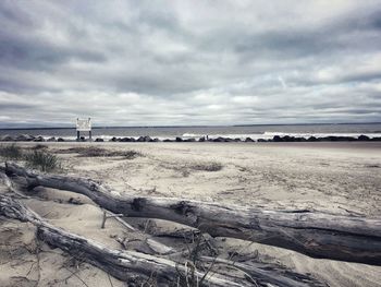 Scenic view of beach against cloudy sky