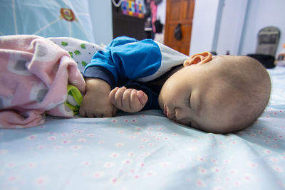 Close-up of baby sleeping on bed