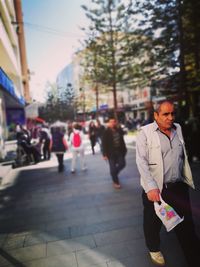 People walking on footpath in city