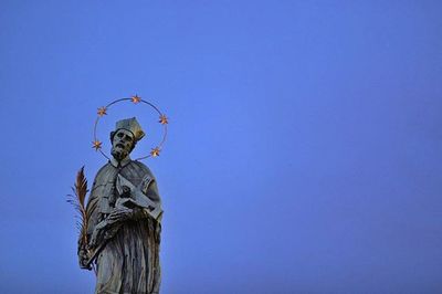 Low angle view of people against blue sky