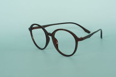 High angle view of eyeglasses on table against blue background