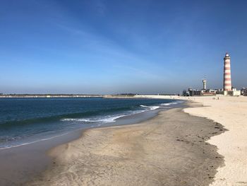 Scenic view of beach against blue sky