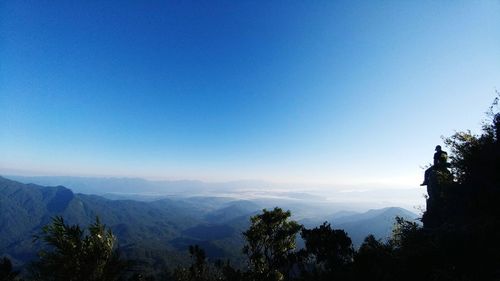 Scenic view of silhouette mountains against clear blue sky