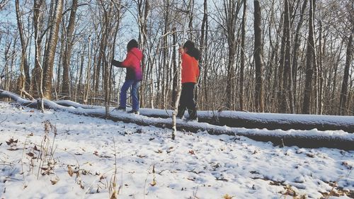 Rear view of people on snow covered land