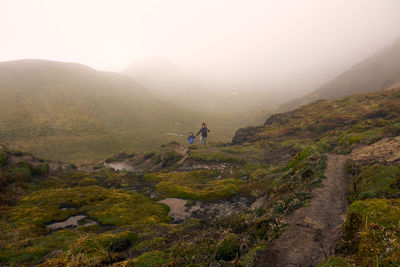 Mother and son standing on mountain