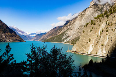 Scenic view of lake and mountains against blue sky