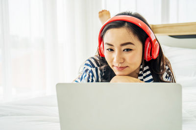 Portrait of girl using mobile phone on bed