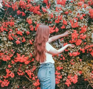 Midsection of woman standing by flowering plants