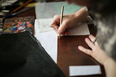 Drawing a sketch on a plate of copper with a metal pen, close-up, materials in a home creative 