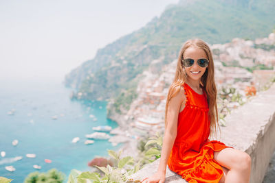 Portrait of smiling young woman against sea