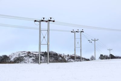 Low angle view of pylons against clear sky