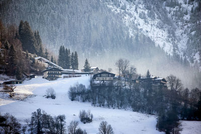 Alpine village on snowed slope of alp mountains in sunny winter austria