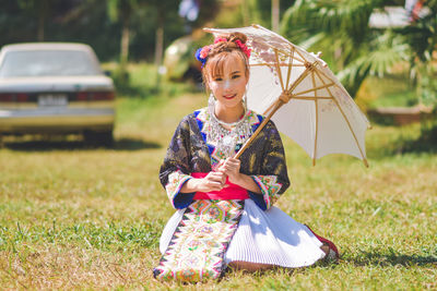 Full length of girl holding umbrella on field